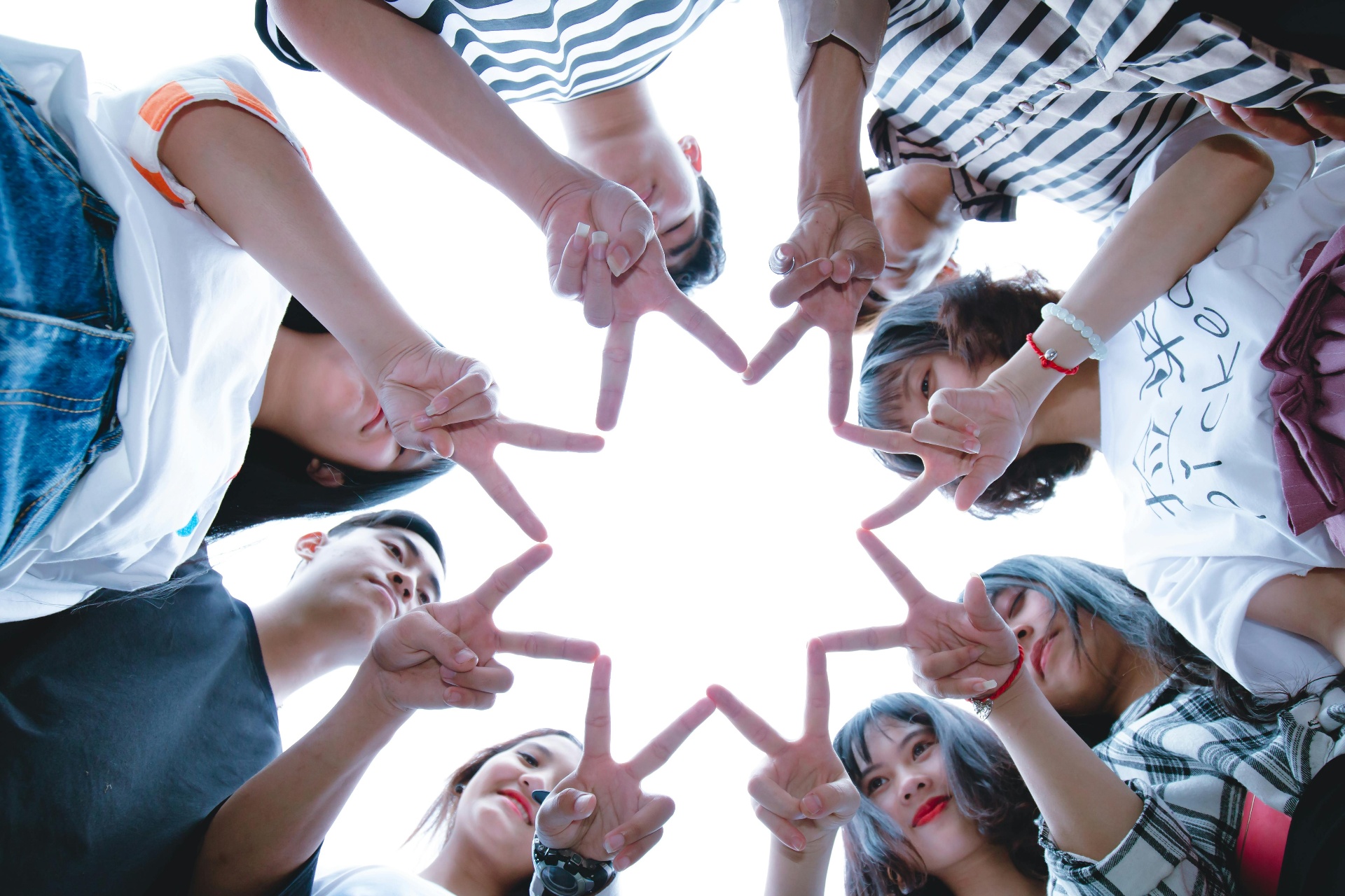 Group of people forming a star shape with their hands